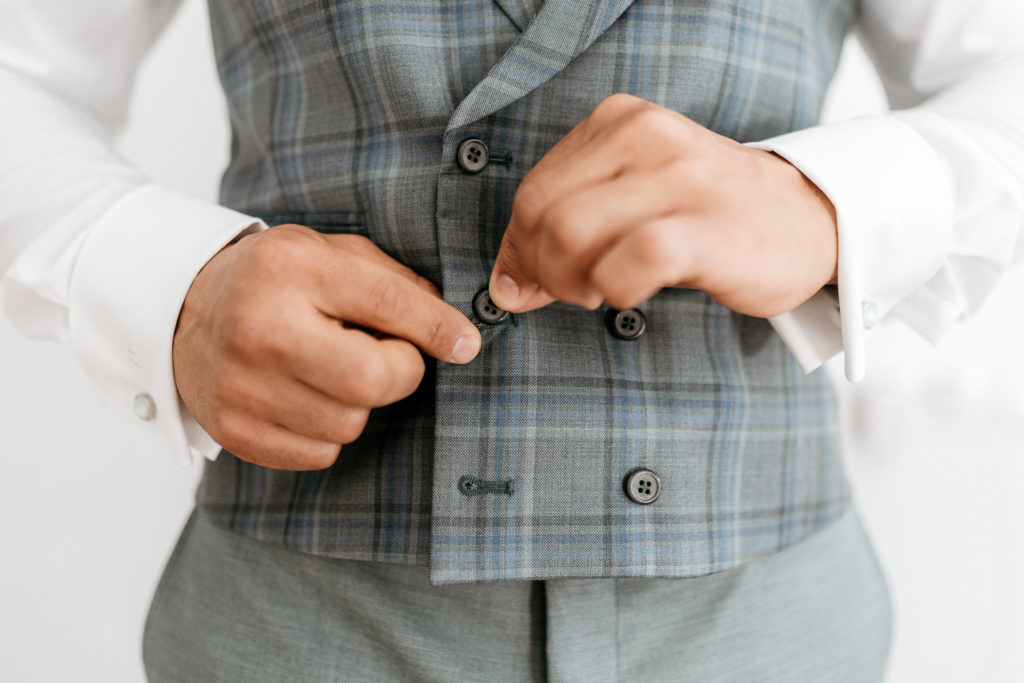 a person buttoning a vest