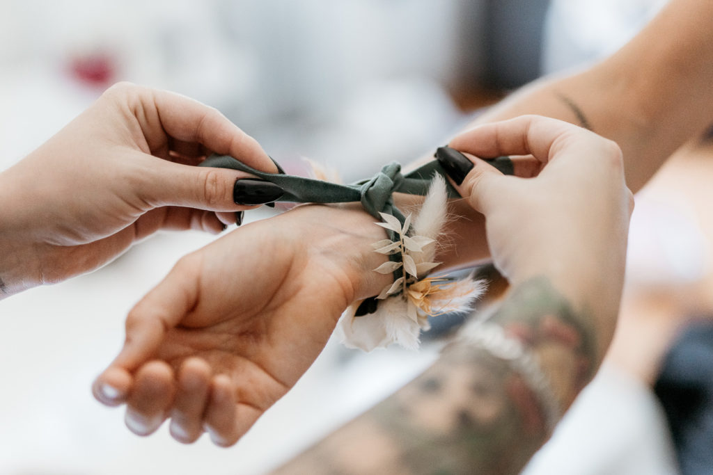 a person tying a bracelet on their wrist