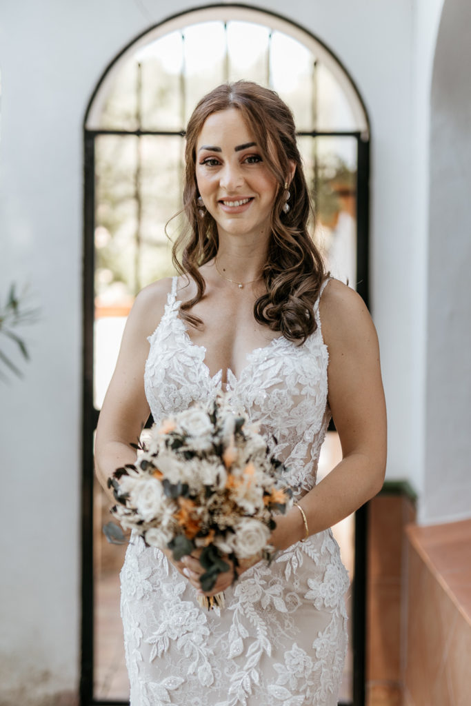 a woman in a white dress holding a bouquet of flowers