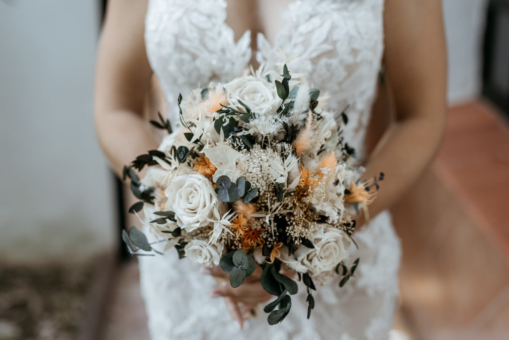 a woman in a white dress holding a bouquet of flowers