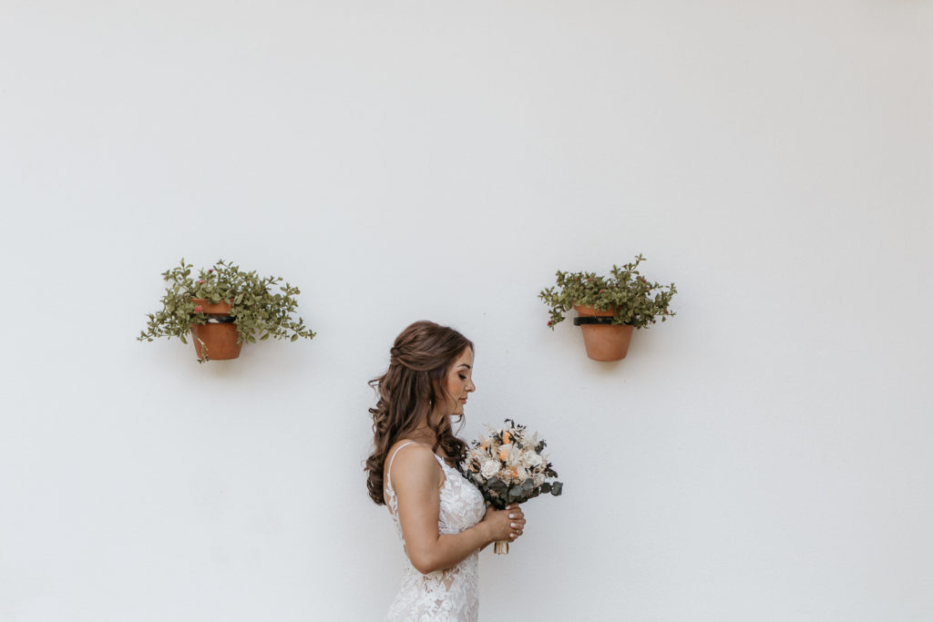 a woman in a white dress holding flowers