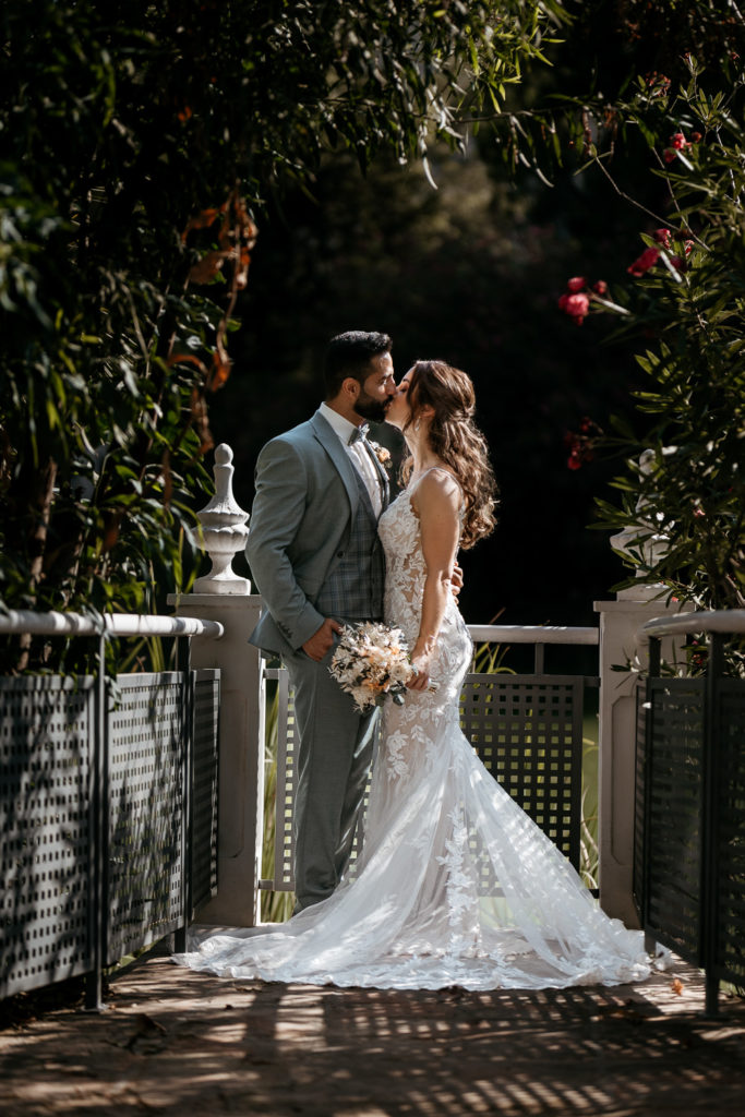 a man and woman kissing on a bridge