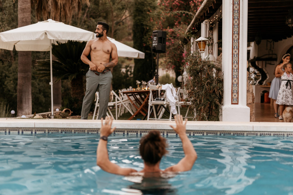 a man in a pool with a woman in the back