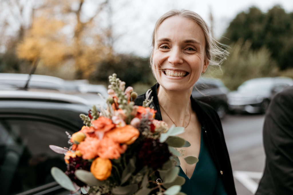 a woman smiling with a bouquet of flowers